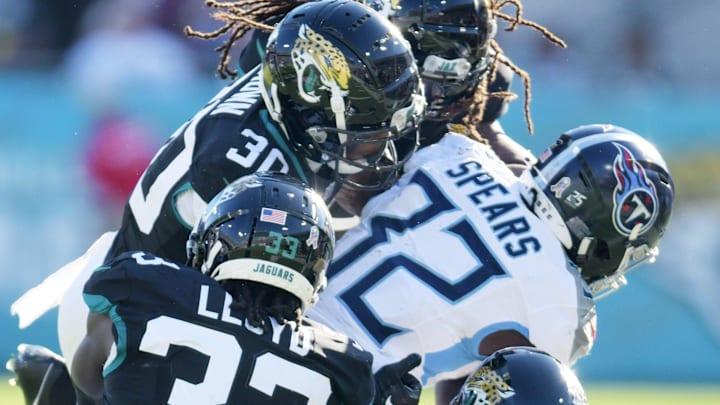 Jacksonville Jaguars safety Andre Cisco (5), linebacker Devin Lloyd (33), cornerback Montaric Brown (30) and, safety Rayshawn Jenkins (2) tackle Tennessee Titans running back Tyjae Spears (32) during third quarter action. The Jacksonville Jaguars hosted the Tennessee Titans at EverBank Stadium in Jacksonville, FL Sunday, November 19, 2023. The Jaguars led 13 to 0 at the half and walked away with a 34 to 14 win over the Titans. [Bob Self/Florida Times-Union]