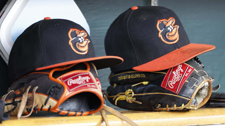 Baltimore Orioles hats and glove sits in dugout Baltimore Orioles hats and glove sits in dugout