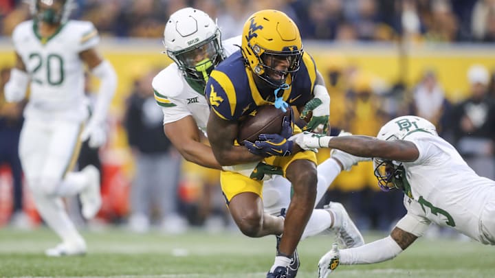 Nov 16, 2024; Morgantown, West Virginia, USA; West Virginia Mountaineers wide receiver Traylon Ray (7) catches a pass and is tackled by Baylor Bears linebacker Keaton Thomas (11) during the first quarter at Mountaineer Field at Milan Puskar Stadium. Mandatory Credit: Ben Queen-Imagn Images