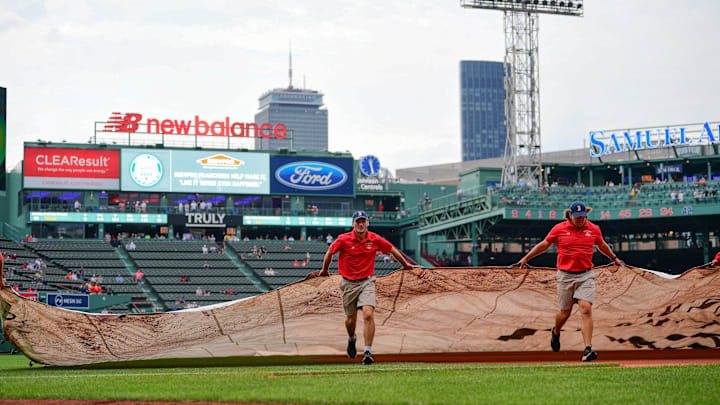 Jun 14, 2024; Boston, Massachusetts, USA; The Red Sox ground crew roll out the in-field tarp in anticipation of rain before a game against the New York Yankees at Fenway Park. Mandatory Credit: Eric Canha-Imagn Images