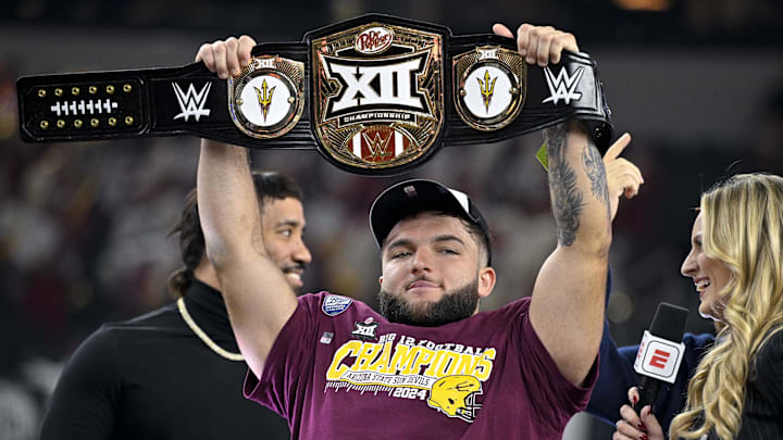 Dec 7, 2024; Arlington, TX, USA; Arizona State Sun Devils running back Cam Skattebo (4) holds up the WWE Big 12 championship belt after the Sun Devils defeat the Iowa State Cyclones and win the 2024 Big 12 Championship at AT&T Stadium. Mandatory Credit: Jerome Miron-Imagn Images