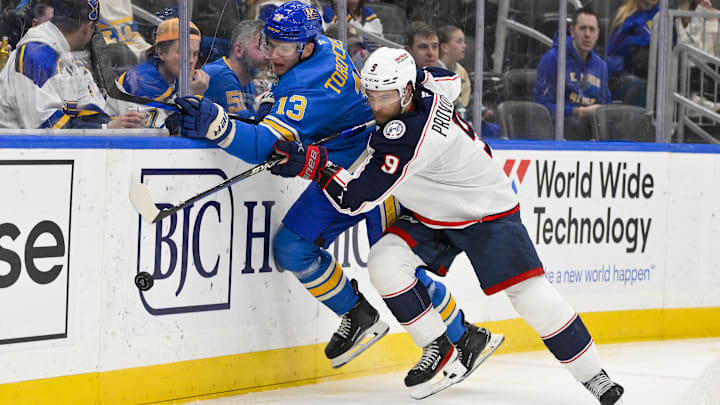 Jan 11, 2025; St. Louis, Missouri, USA;  St. Louis Blues right wing Alexey Toropchenko (13) and Columbus Blue Jackets defenseman Ivan Provorov (9)  battle for the puck during the second period at Enterprise Center. Mandatory Credit: Jeff Curry-Imagn Images