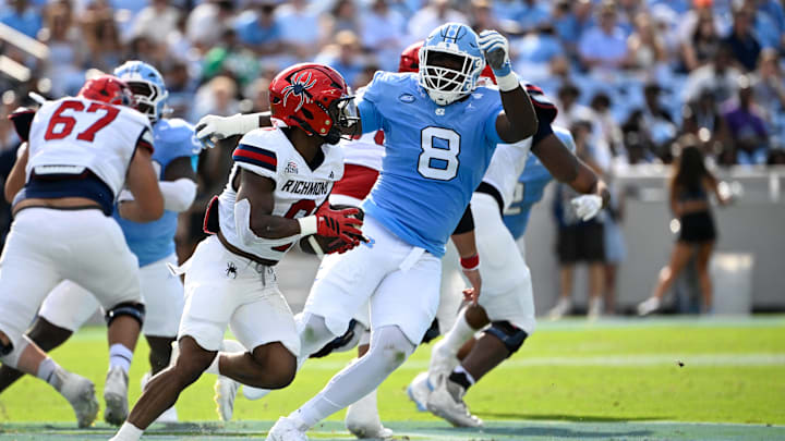 Sep 13, 2025; Chapel Hill, North Carolina, USA; Richmond Spiders running back Andrew King (8) runs as North Carolina Tar Heels defensive lineman Smith Vilbert (8) defends in the second quarter at Kenan Stadium. Mandatory Credit: Bob Donnan-Imagn Images