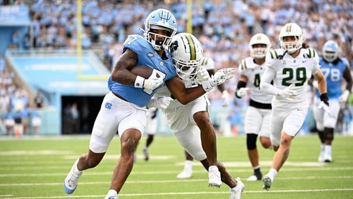 Sep 7, 2024; Chapel Hill, North Carolina, USA; North Carolina Tar Heels wide receiver Christian Hamilton (7) with the ball as Charlotte 49ers defensive back Al-Ma'hi Ali (0) defends in the second quarter at Kenan Memorial Stadium. Mandatory Credit: Bob Donnan-Imagn Images Sep 7, 2024; Chapel Hill, North Carolina, USA; North Carolina Tar Heels wide receiver Christian Hamilton (7) with the ball as Charlotte 49ers defensive back Al-Ma'hi Ali (0) defends in the second quarter at Kenan Memorial Stadium. Mandatory Credit: Bob Donnan-Imagn Images