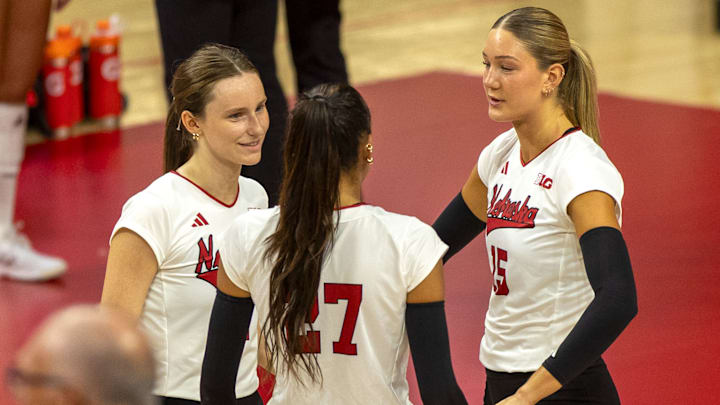 Nebraska setter Bergen Reilly, outside hitter Harper Murray, and middle blocker Andi Jackson talk before first serve. All three earned first-team All-American honors Wednesday. 