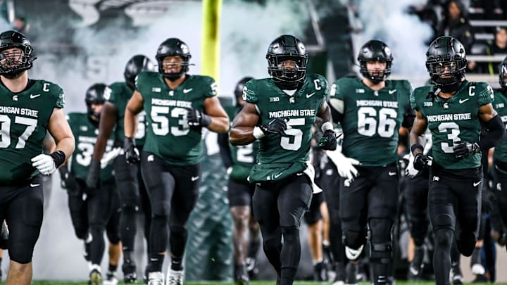 Michigan State's Nathan Carter, center, and the team take the field before the football game against Purdue on Friday, Nov. 22, 2024, at Spartan Stadium in East Lansing.
