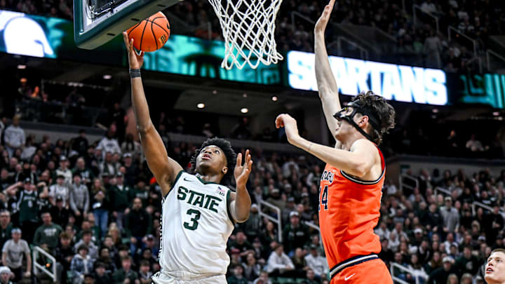 Michigan State's Cam Ward, left, scores as Illinois' Zvonimir Ivisic defends during the first half on Saturday, Feb. 7, 2026, at the Breslin Center in East Lansing.