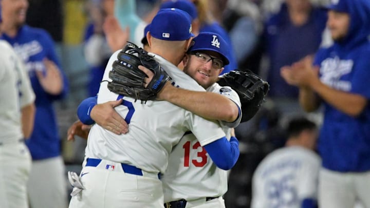 Oct 18, 2025; Los Angeles, California, USA; Los Angeles Dodgers first baseman Freddie Freeman (5) and third baseman Max Muncy (13) embrace after the final out of game five of the NLCS in the 2025 MLB playoffs defeating the Milwaukee Brewers at Dodger Stadium. Mandatory Credit: Jayne Kamin-Oncea-Imagn Images