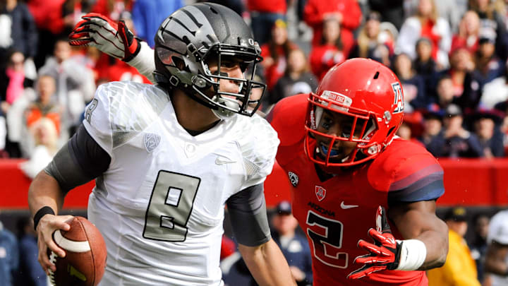 Nov 23, 2013; Tucson, AZ, USA; Oregon Ducks quarterback Marcus Mariota (8) runs the ball under pressure from Arizona Wildcats linebacker Marquis Flowers (2) during the first quarter at Arizona Stadium. Arizona beat Oregon 42-16. Mandatory Credit: Casey Sapio-Imagn Images Nov 23, 2013; Tucson, AZ, USA; Oregon Ducks quarterback Marcus Mariota (8) runs the ball under pressure from Arizona Wildcats linebacker Marquis Flowers (2) during the first quarter at Arizona Stadium. Arizona beat Oregon 42-16. Mandatory Credit: Casey Sapio-Imagn Images