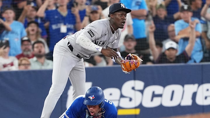 Jun 30, 2025; Toronto, Ontario, CAN; Toronto Blue Jays outfielder George Springer (4) is tagged out at third base by New York Yankees third baseman Jazz Chisholm Jr. (13) during the sixth inning at Rogers Centre. Mandatory Credit: Nick Turchiaro-Imagn Images