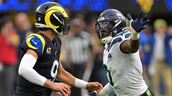 Nov 16, 2025; Inglewood, California, USA;  Los Angeles Rams quarterback Matthew Stafford (9) is pressured by Seattle Seahawks linebacker DeMarcus Lawrence (0) during the game at SoFi Stadium. Mandatory Credit: Jayne Kamin-Oncea-Imagn Images