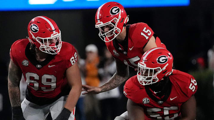 Georgia quarterback Carson Beck (15) speaks with Georgia offensive lineman Tate Ratledge (69) and Georgia offensive lineman Micah Morris (56) during the first half of a NCAA college football game against Tennessee in Athens, Ga., on Saturday, Nov. 16, 2024.