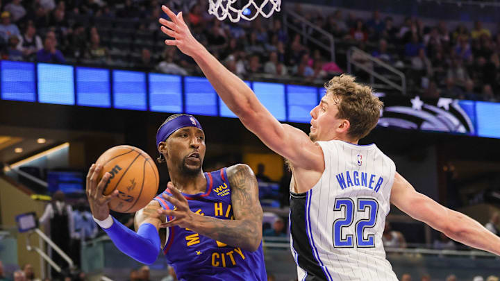Denver Nuggets guard Kentavious Caldwell-Pope (5) passes the ball around Orlando Magic forward Franz Wagner (22) during the second quarter at Amway Center. Denver Nuggets guard Kentavious Caldwell-Pope (5) passes the ball around Orlando Magic forward Franz Wagner (22) during the second quarter at Amway Center.