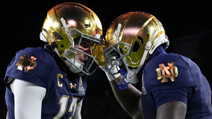 Notre Dame Fighting Irish quarterback Riley Leonard (13) and Notre Dame Fighting Irish running back Jeremiyah Love (4) celebrate a touchdown during the first half of a game between the Indiana Hoosiers and the Notre Dame Fighting Irish in first round of the College Football Playoff on Friday, Dec. 20, 2024, in South Bend. Notre Dame defeated Indiana 27-17. Notre Dame Fighting Irish quarterback Riley Leonard (13) and Notre Dame Fighting Irish running back Jeremiyah Love (4) celebrate a touchdown during the first half of a game between the Indiana Hoosiers and the Notre Dame Fighting Irish in first round of the College Football Playoff on Friday, Dec. 20, 2024, in South Bend. Notre Dame defeated Indiana 27-17.
