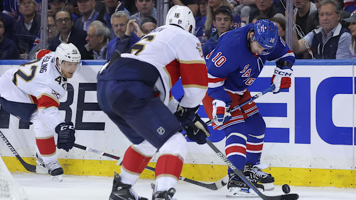 May 22, 2024; New York, New York, USA; New York Rangers left wing Artemi Panarin (10) fights for the puck against Florida Panthers defenseman Gustav Forsling (42) and center Aleksander Barkov (16) during the third period of game one of the Eastern Conference Final of the 2024 Stanley Cup Playoffs at Madison Square Garden. Mandatory Credit: Brad Penner-USA TODAY Sports
