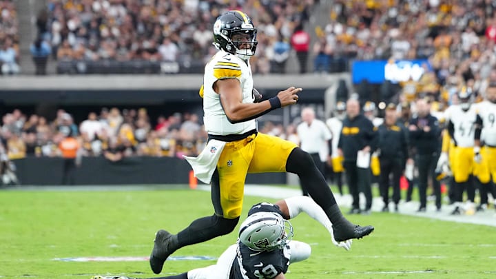 Oct 13, 2024; Paradise, Nevada, USA; Pittsburgh Steelers quarterback Justin Fields (2) evades the tackle attempt of Las Vegas Raiders defensive end Charles Snowden (49) during the second quarter at Allegiant Stadium. Mandatory Credit: Stephen R. Sylvanie-Imagn Images