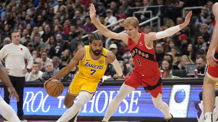 Nov 1, 2024; Toronto, Ontario, CAN; Los Angeles Lakers guard Gabe Vincent (7) drives to the net past Toronto Raptors guard Gradey Dick (1) during the first half at Scotiabank Arena. Mandatory Credit: John E. Sokolowski-Imagn Images