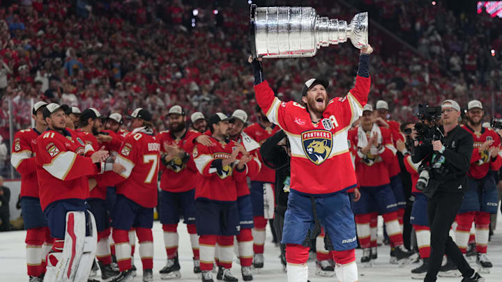 Jun 17, 2025; Sunrise, Florida, USA; Florida Panthers left wing Matthew Tkachuk (19) hoist the Stanley Cup after game six of the 2025 Stanley Cup Final against the Edmonton Oilers at Amerant Bank Arena. Mandatory Credit: Jim Rassol-Imagn Images