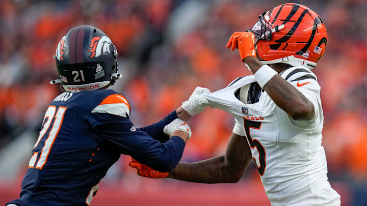 Denver Broncos cornerback Riley Moss (21) pulls on the jersey of Cincinnati Bengals wide receiver Tee Higgins (5) for a pass interference penalty in the first quarter of the NFL Week 4 Monday Night Football game between the Denver Broncos and the Cincinnati Bengals at Empower Field at Mile High in Denver on Monday, Sept. 29, 2025.