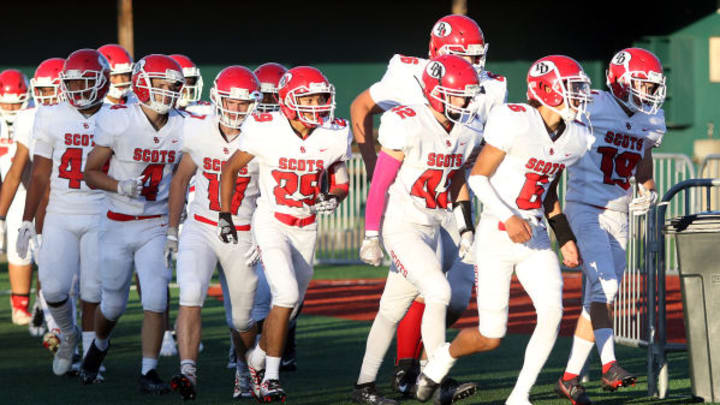 David Douglas High School football players run onto the field.