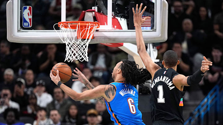 Feb 4, 2026; San Antonio, Texas, USA; Oklahoma City Thunder forward Jaylin Williams (6) drives to the basket past San Antonio Spurs forward Victor Wembanyama (1) during the first half at Frost Bank Center. Mandatory Credit: Scott Wachter-Imagn Images