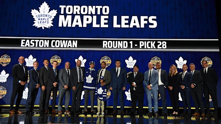 Jun 28, 2023; Nashville, Tennessee, USA; Toronto Maple Leafs draft pick Easton Cowan stands with Leafs staff after being selected with the twenty eighth pick in round one of the 2023 NHL Draft at Bridgestone Arena. Mandatory Credit: Christopher Hanewinckel-Imagn Images