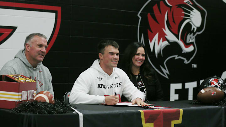Linebacker Will Hawthorne signs a letter of intent for Iowa State football, with his parents.