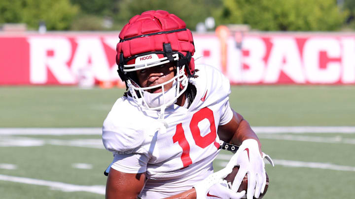 Aug 14, 2025; Fayetteville, AR, USA; Arkansas Razorbacks wide receiver Antonio Jordan (19) tucks the ball away after a catch during practice. Mandatory Credit: Nelson Chenault-Imagn Images