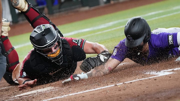 Arizona Diamondbacks catcher James McCann (8) tags out Colorado Rockies baserunner Warming Bernabel (25) at home plate at Chase Field on Aug. 10, 2025.