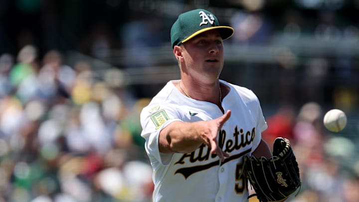 Jun 22, 2025; West Sacramento, California, USA; Athletics pitcher Jack Perkins (50) tosses to first for an out against the Cleveland Guardians during the seventh inning at Sutter Health Park. Mandatory Credit: Dennis Lee-Imagn Images