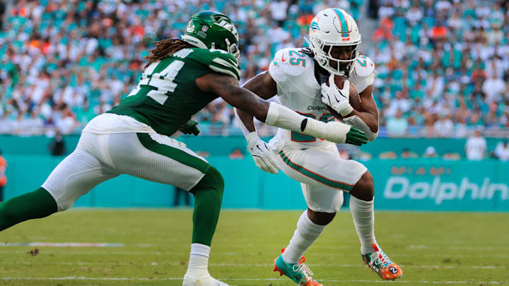 Miami Dolphins running back Jaylen Wright (25) runs with the football against New York Jets linebacker Jamien Sherwood (44) during the second quarter at Hard Rock Stadium.