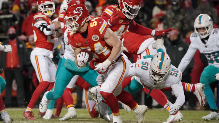 Jan 13, 2024; Kansas City, Missouri, USA; Kansas City Chiefs linebacker Leo Chenal (54) on offense runs the ball ahead of Miami Dolphins linebacker Calvin Munson (50) during the first half of the 2024 AFC wild card game at GEHA Field at Arrowhead Stadium. Mandatory Credit: Denny Medley-USA TODAY Sports