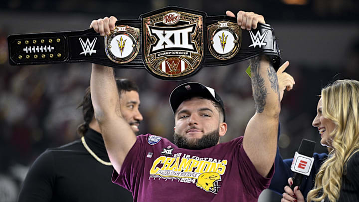 Dec 7, 2024; Arlington, TX, USA; Arizona State Sun Devils running back Cam Skattebo (4) holds up the WWE Big 12 championship belt after the Sun Devils defeat the Iowa State Cyclones and win the 2024 Big 12 Championship at AT&T Stadium. Mandatory Credit: Jerome Miron-Imagn Images Dec 7, 2024; Arlington, TX, USA; Arizona State Sun Devils running back Cam Skattebo (4) holds up the WWE Big 12 championship belt after the Sun Devils defeat the Iowa State Cyclones and win the 2024 Big 12 Championship at AT&T Stadium. Mandatory Credit: Jerome Miron-Imagn Images