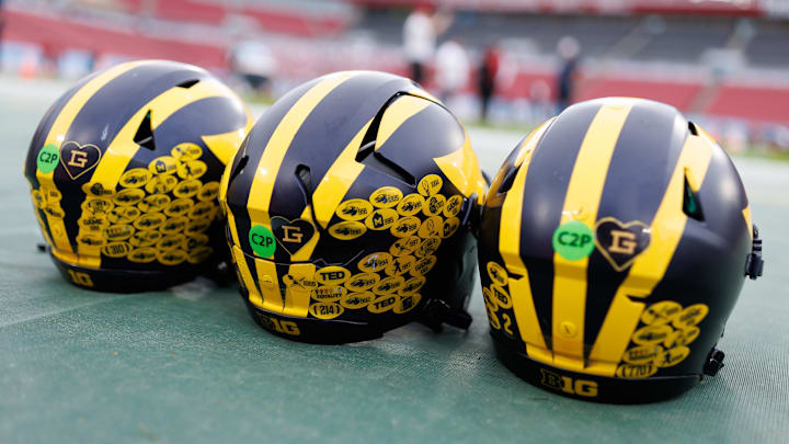 Dec 31, 2024; Tampa, FL, USA; Michigan Wolverines quarterback helmets sit on the field before a game against the Alabama Crimson Tide at Raymond James Stadium. Mandatory Credit: Matt Pendleton-Imagn Images