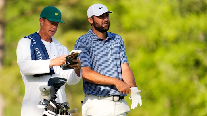 Scottie Scheffler consults with his caddie Ted Scott.
