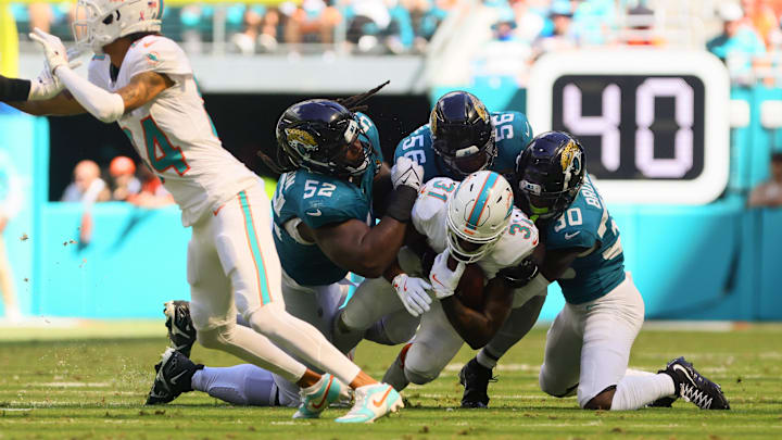 Sep 8, 2024; Miami Gardens, Florida, USA; Miami Dolphins running back Raheem Mostert (31) runs with the football against Jacksonville Jaguars defensive tackle DaVon Hamilton (52), linebacker Yasir Abdullah (56) and cornerback Montaric Brown (30) during the fourth quarter at Hard Rock Stadium. Mandatory Credit: Sam Navarro-Imagn Images