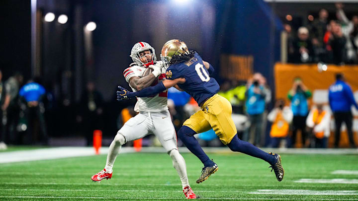 Ohio State Buckeyes running back TreVeyon Henderson (32) runs the ball against Notre Dame Fighting Irish safety Xavier Watts (0) during the College Football Playoff championship at Mercedes-Benz Stadium in Atlanta on Jan. 20, 2025.
