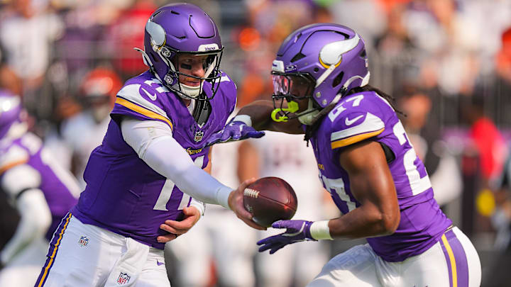 Sep 21, 2025; Minneapolis, Minnesota, USA; Minnesota Vikings quarterback Carson Wentz (11) hands off to running back Jordan Mason (27) against the Cincinnati Bengals during the first half at U.S. Bank Stadium.