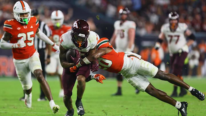 Sep 27, 2024; Miami Gardens, Florida, USA; Virginia Tech Hokies running back Bhayshul Tuten (33) runs with the football against Miami Hurricanes defensive back Zaquan Patterson (20) during the fourth quarter at Hard Rock Stadium. Mandatory Credit: Sam Navarro-Imagn Images Sep 27, 2024; Miami Gardens, Florida, USA; Virginia Tech Hokies running back Bhayshul Tuten (33) runs with the football against Miami Hurricanes defensive back Zaquan Patterson (20) during the fourth quarter at Hard Rock Stadium. Mandatory Credit: Sam Navarro-Imagn Images