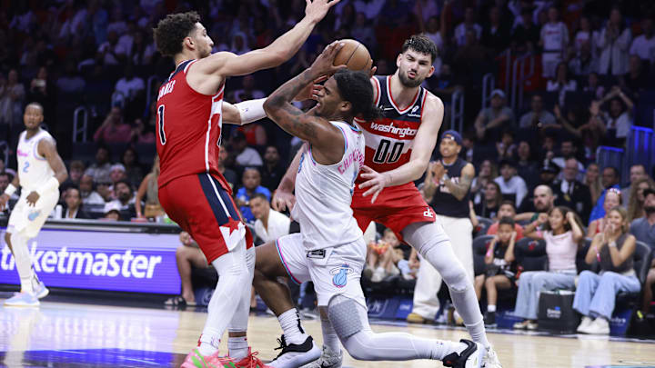 Apr 13, 2025; Miami, Florida, USA;  Washington Wizards guard Colby Jones (1) and forward Tristan Vukcevic (00) defend Miami Heat guard Josh Christopher (8) during the second half at Kaseya Center. Mandatory Credit: Rhona Wise-Imagn Images