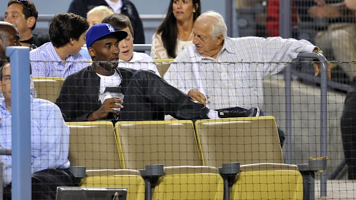 July 31, 2013; Los Angeles, CA, USA; Los Angeles Lakers player Kobe Bryant in attendance speaks with former manager Tommy Lasorda as the Los Angeles Dodgers play against the New York Yankees at Dodger Stadium. Mandatory Credit: Gary A. Vasquez-Imagn Images