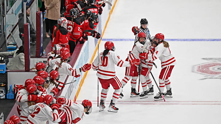 Wisconsin right wing Kirsten Simms (27) is mobbed by teammates after scoring on a penalty shot with 18.9 seconds left to tie the NCAA women's hockey Frozen Four championship game Sunday, March 23, 2025, at Ridder Arena in Minneapolis, Minnesota.