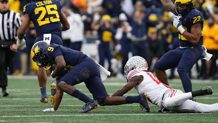 Nov 25, 2023; Ann Arbor, Michigan, USA; Michigan Wolverines defensive back Rod Moore (9) intercepts a pass intended for Ohio State Buckeyes wide receiver Marvin Harrison Jr. (18) near the end of the second half of the NCAA football game at Michigan Stadium. Ohio State lost 30-24.