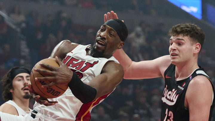 Jan 11, 2025; Portland, Oregon, USA; Miami Heat center Bam Adebayo (13) grabs a rebound during the first half against Portland Trail Blazers center Donovan Clingan (23) at Moda Center. Mandatory Credit: Troy Wayrynen-Imagn Images