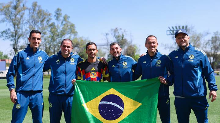 Vinicius Lima y André Jardine, junto a su cuerpo técnico, posan con la bandera de Brasil en las instalaciones del América Vinicius Lima y André Jardine, junto a su cuerpo técnico, posan con la bandera de Brasil en las instalaciones del América