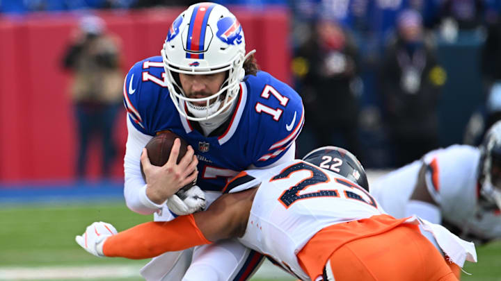 Jan 12, 2025; Orchard Park, New York, USA; Buffalo Bills quarterback Josh Allen (17) is tackled by Denver Broncos safety Brandon Jones (22) during the first quarter in an AFC wild card game at Highmark Stadium. 