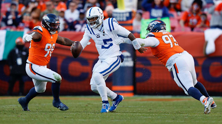 Dec 15, 2024; Denver, Colorado, USA; Indianapolis Colts quarterback Anthony Richardson (5) runs through the tackle of Denver Broncos defensive tackle D.J. Jones (93) and defensive end John Franklin-Myers (98) in the second quarter at Empower Field at Mile High. Mandatory Credit: Isaiah J. Downing-Imagn Images