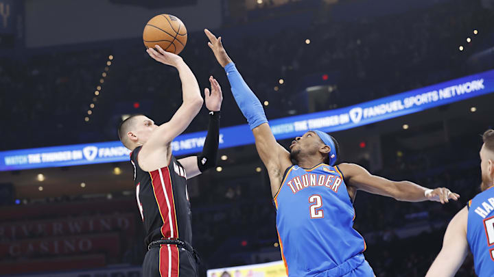 Feb 12, 2025; Oklahoma City, Oklahoma, USA; Miami Heat guard Tyler Herro (14) shoots as Oklahoma City Thunder guard Shai Gilgeous-Alexander (2) defends during the first quarter at Paycom Center. Mandatory Credit: Alonzo Adams-Imagn Images