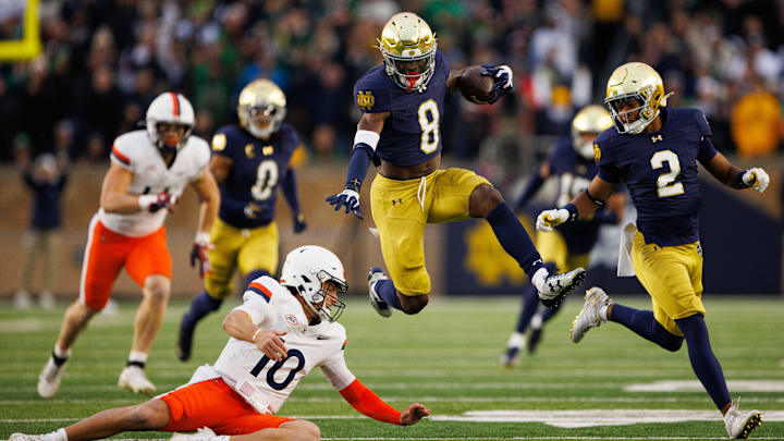 Notre Dame safety Adon Shuler (8) hurdles over Virginia quarterback Anthony Colandrea (10) after intercepting the ball during a NCAA college football game at Notre Dame Stadium on Saturday, Nov. 16, 2024, in South Bend.