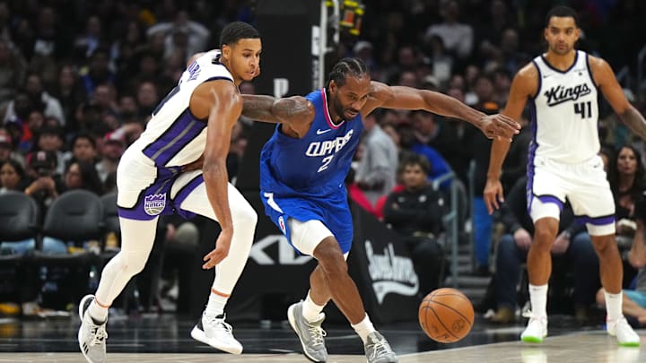 Dec 6, 2023; Los Angeles, California, USA; Sacramento Kings forward Keegan Murray (13) and LA Clippers forward Kawhi Leonard (2) reach for the ball in the second half at Crypto.com Arena. Mandatory Credit: Kirby Lee-Imagn Images